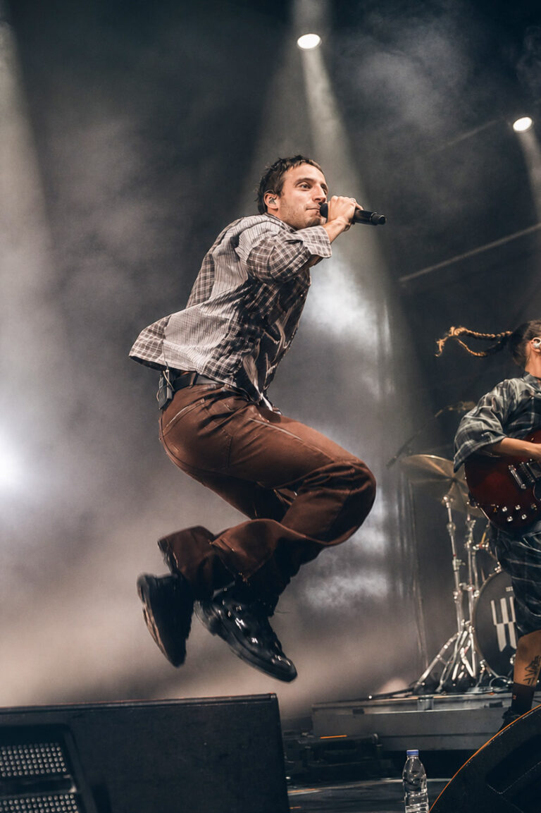 Wos jumping on stage with the band behind him — Wos live in Buenos Aires, photographed by Anita Almaraz.