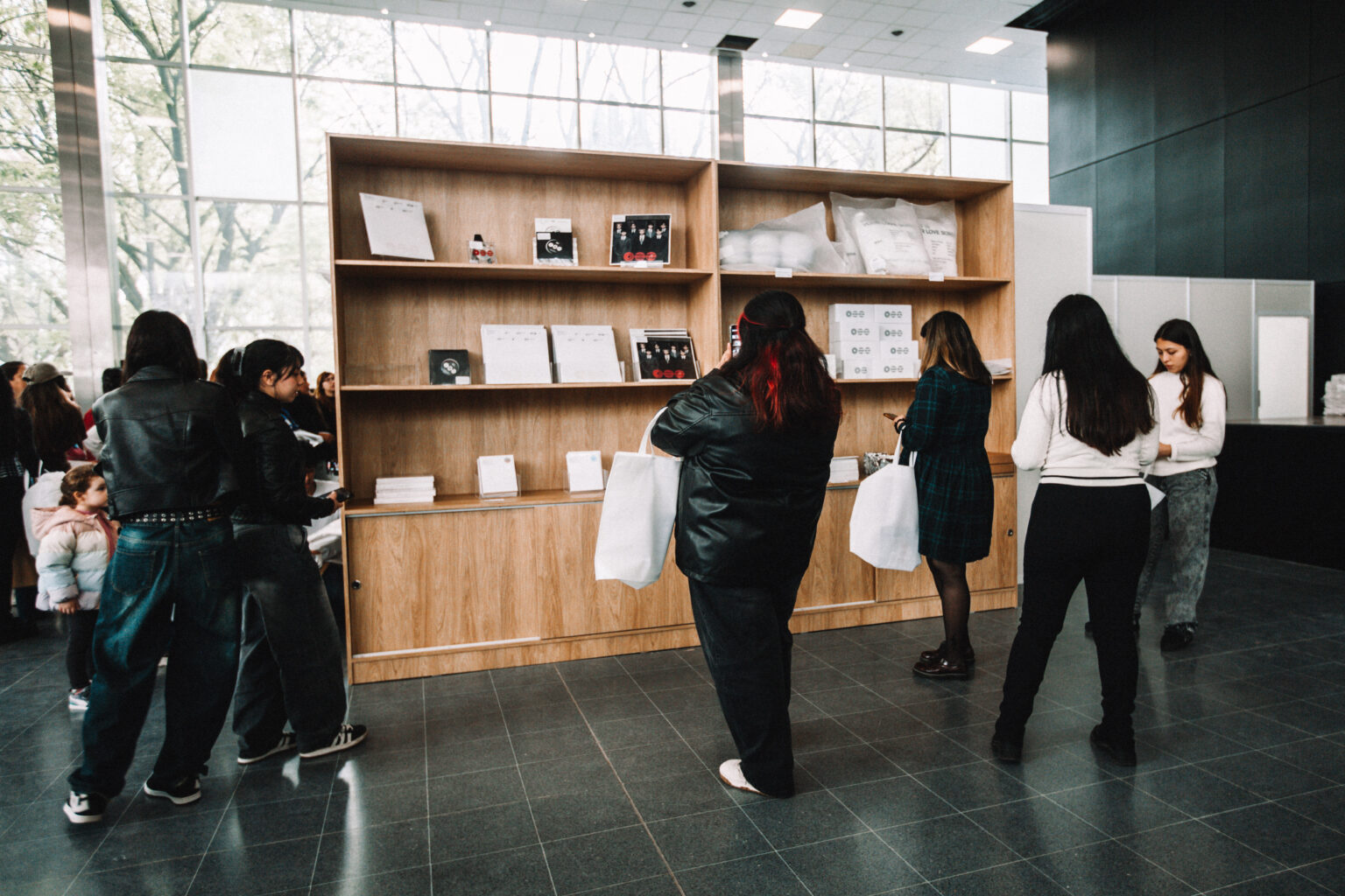 Visitors browsing the merchandise shelves at the BTS POP-UP: ARIRANG IN BUENOS AIRES, Centro de Convenciones Dr. Arturo Frondizi, Vicente Lopez, 2026 — photographed by Anita Almaraz for K-HipHop Argentina