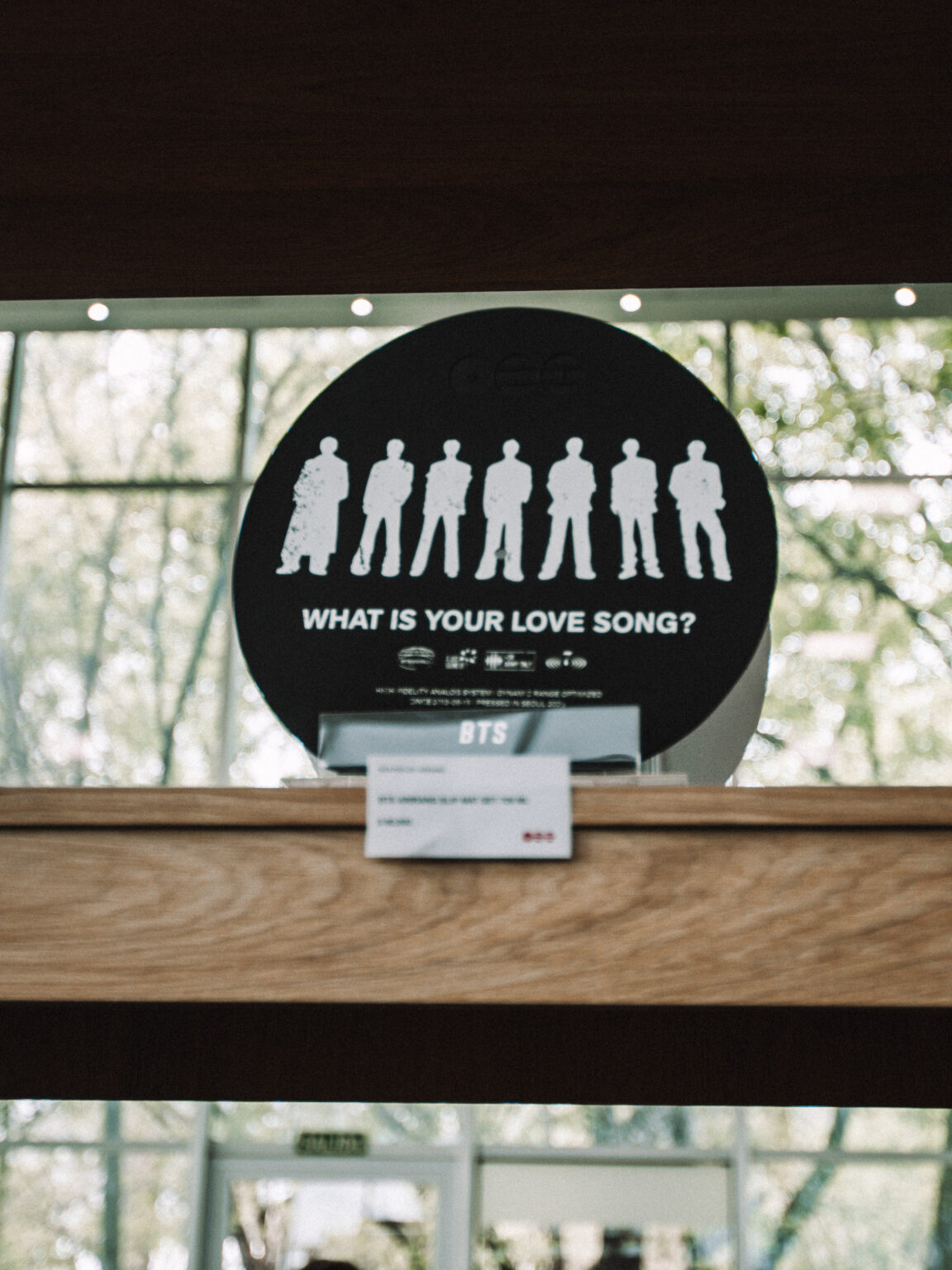 “What is your love song?” sign on the counter at the BTS POP-UP: ARIRANG IN BUENOS AIRES, Centro de Convenciones Dr. Arturo Frondizi, Vicente Lopez, 2026 — photographed by Anita Almaraz for K-HipHop Argentina
