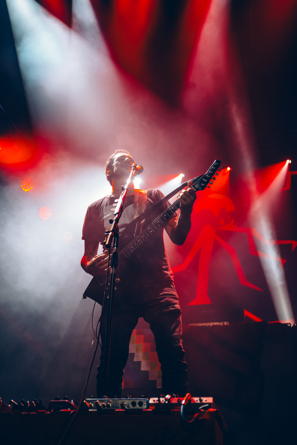 Guitarist in red light with smoke behind him — Divididos at Estadio Obras Sanitarias, Buenos Aires, 19 January 2024. Photographed by Anita Almaraz.
