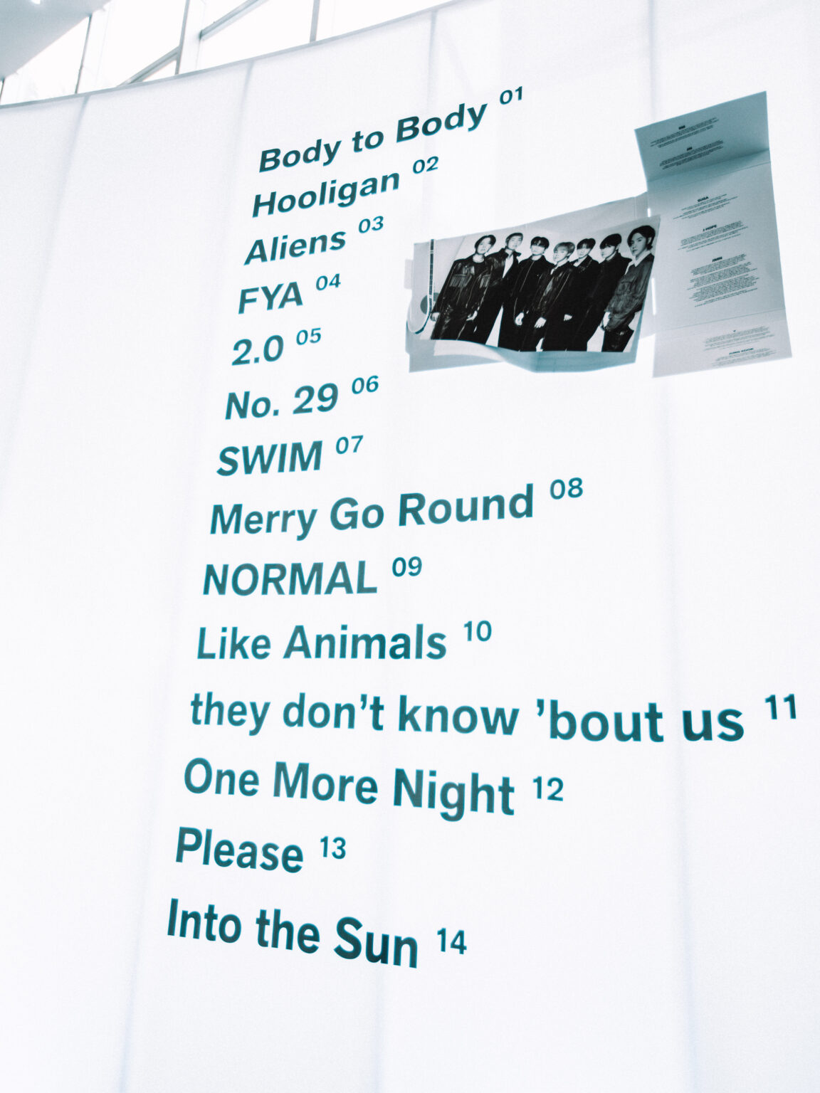 Tracklist panel listing the songs in the exhibition at the BTS POP-UP: ARIRANG IN BUENOS AIRES, Centro de Convenciones Dr. Arturo Frondizi, Vicente Lopez, 2026 — photographed by Anita Almaraz for K-HipHop Argentina