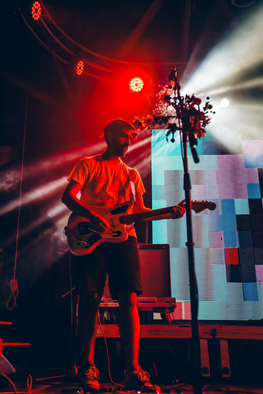 A bass player in red light against a pixelated video wall &mdash; FestiLaptra at Ciudad Cultural Konex, Buenos Aires, 17 February 2024. Photographed by Anita Almaraz.