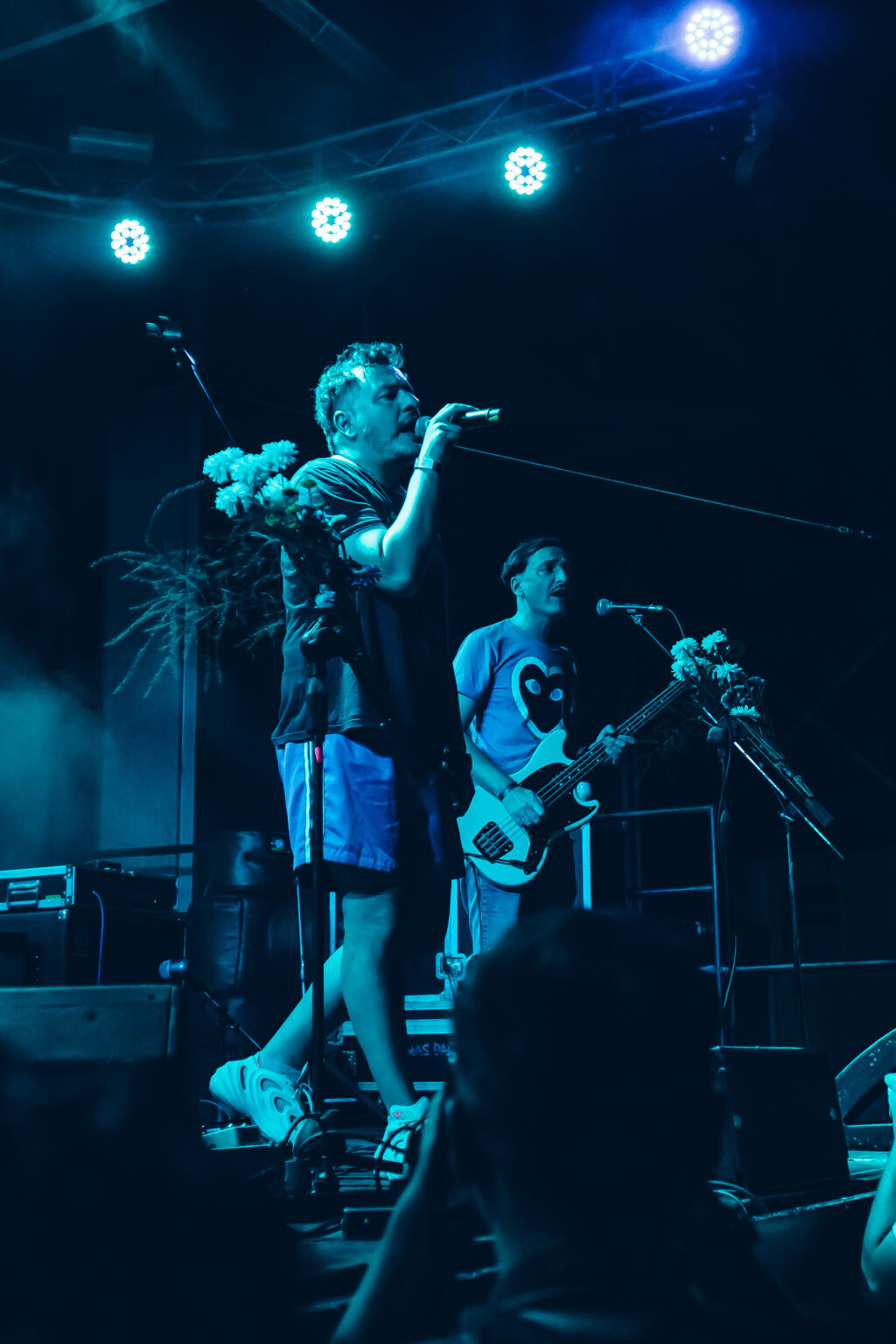 Two musicians sharing a microphone at the front of the stage &mdash; FestiLaptra at Ciudad Cultural Konex, Buenos Aires, 17 February 2024. Photographed by Anita Almaraz.