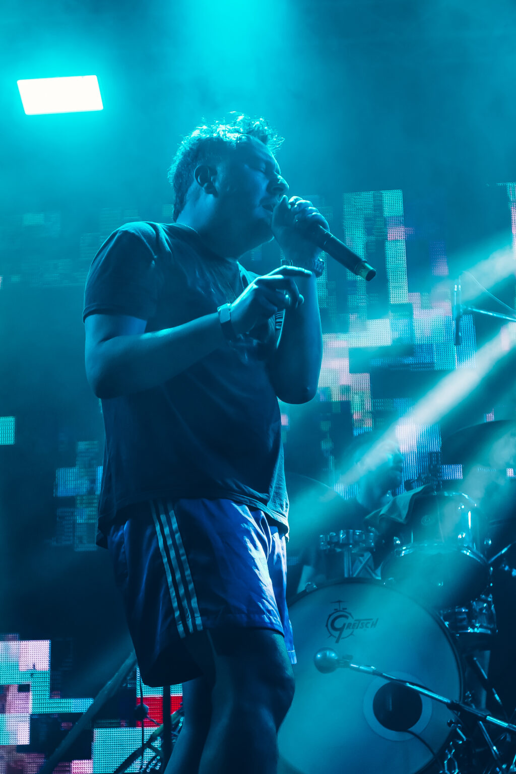 A singer turning his face into the light &mdash; FestiLaptra at Ciudad Cultural Konex, Buenos Aires, 17 February 2024. Photographed by Anita Almaraz.