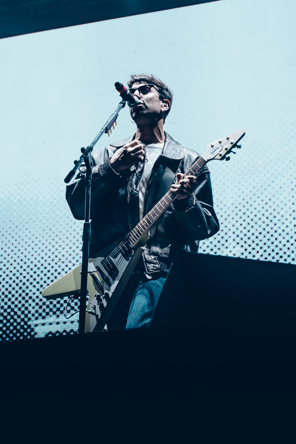 Conociendo Rusia with his guitar against the stage screen — Festival Buena Vibra, Ciudad Universitaria, Buenos Aires, 2024. Photographed by Anita Almaraz.
