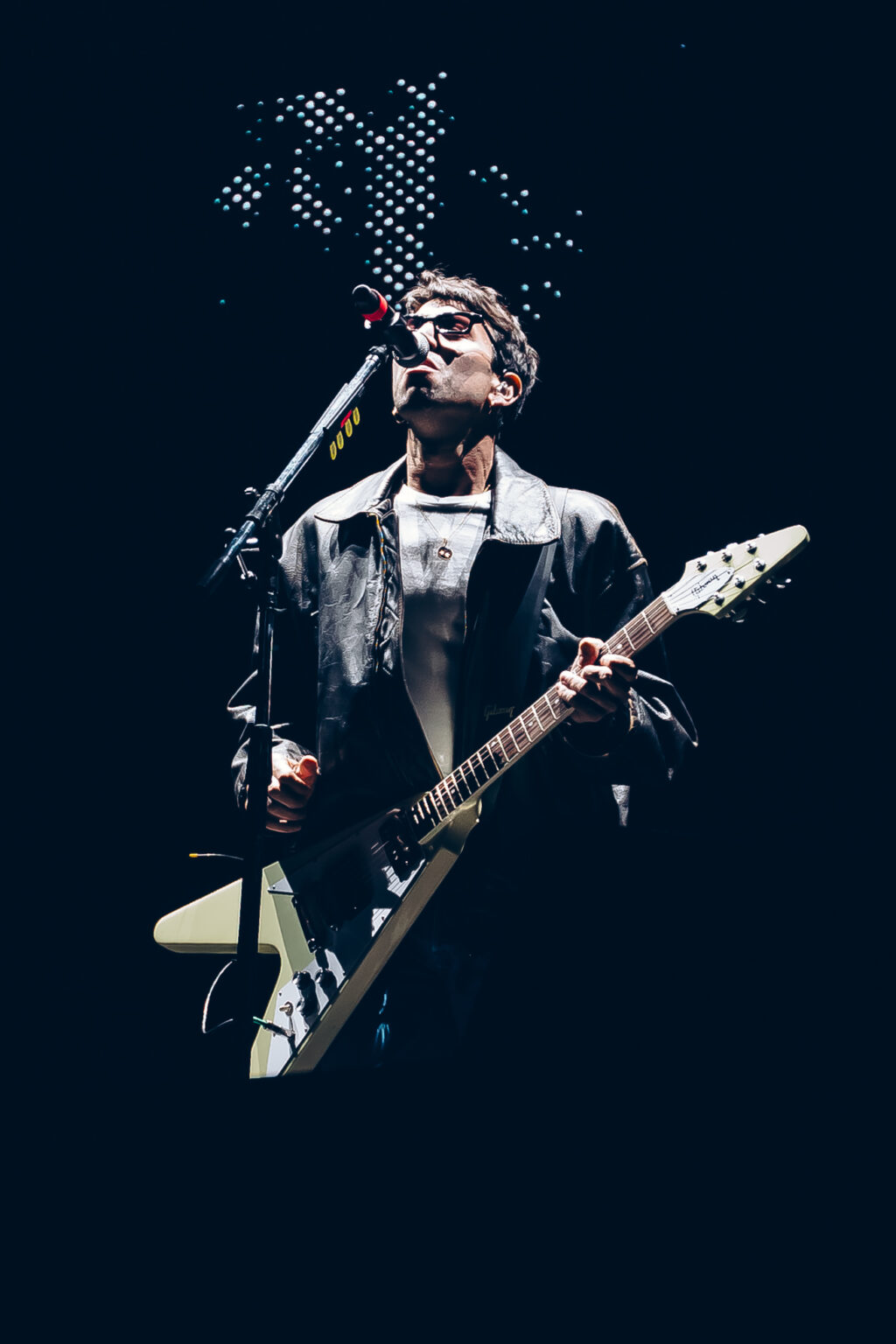 Conociendo Rusia singing with his guitar under white light — Festival Buena Vibra, Ciudad Universitaria, Buenos Aires, 2024. Photographed by Anita Almaraz.