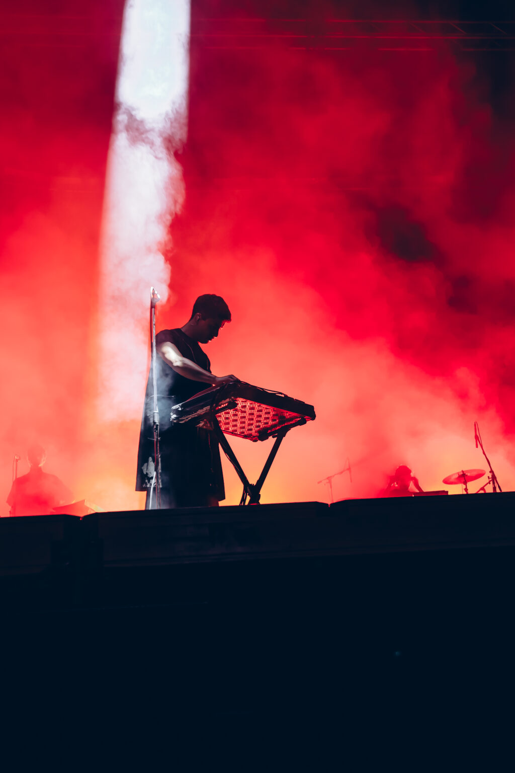 A musician at the synths inside a column of white smoke — Festival Buena Vibra, Ciudad Universitaria, Buenos Aires, 2024. Photographed by Anita Almaraz.