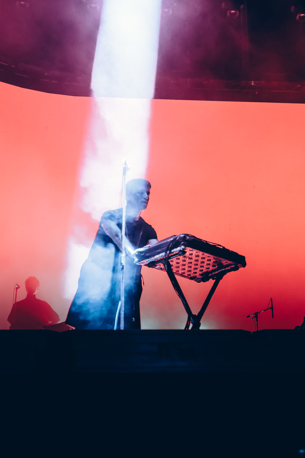 The stage lit red with a column of smoke rising — Festival Buena Vibra, Ciudad Universitaria, Buenos Aires, 2024. Photographed by Anita Almaraz.