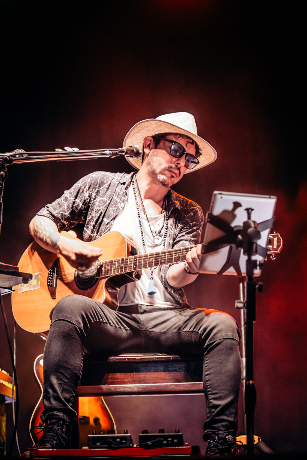 The artist seated with the acoustic guitar, seen wide — Lisandro Aristimuño at Ciudad Cultural Konex, Buenos Aires, 11 December 2021. Photographed by Anita Almaraz.