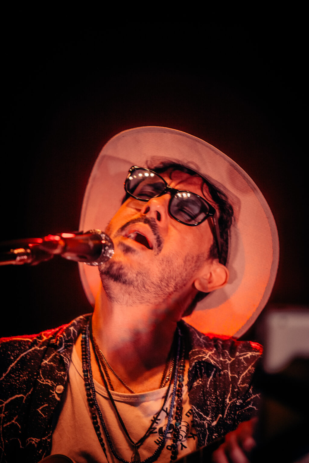 The artist singing with his head back in the red smoke — Lisandro Aristimuño at Ciudad Cultural Konex, Buenos Aires, 11 December 2021. Photographed by Anita Almaraz.