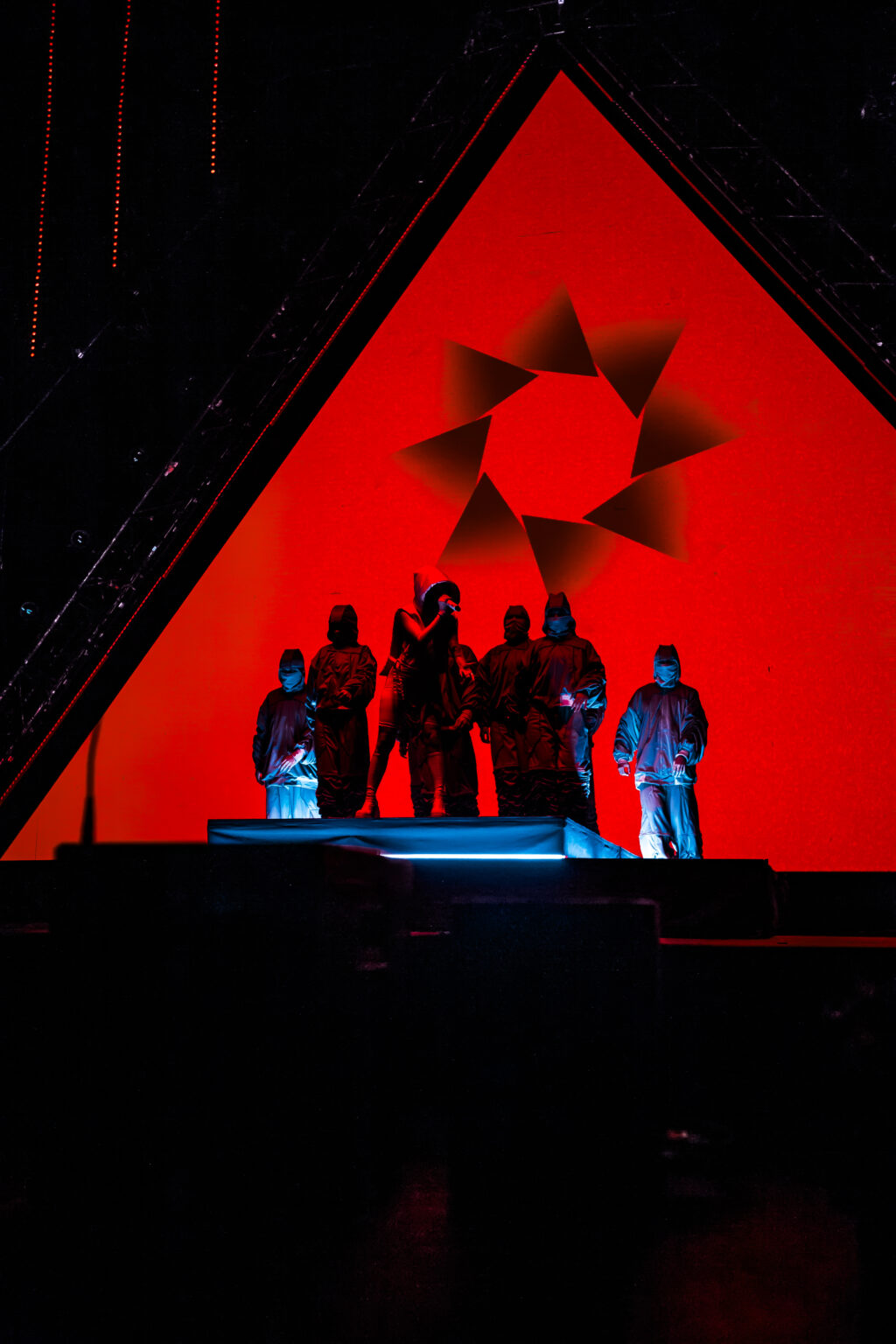 Nicki Nicole and her dancers in silhouette against a red graphic backdrop — Movistar Arena, Buenos Aires, August 2023. Photographed by Anita Almaraz for Agencia Télam.