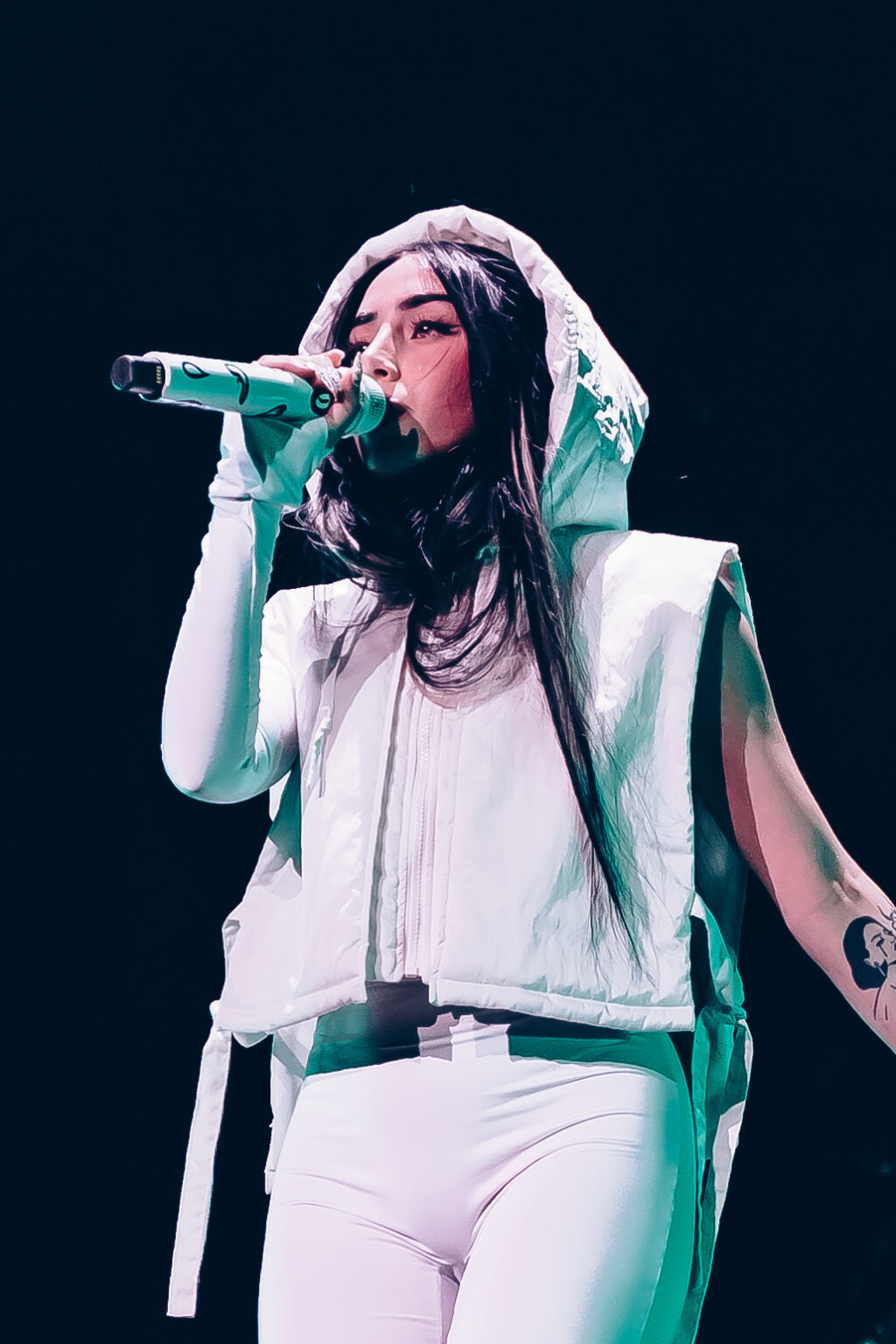 Nicki Nicole performing in a white hooded outfit, close-up — Movistar Arena, Buenos Aires, August 2023. Photographed by Anita Almaraz for Agencia Télam.