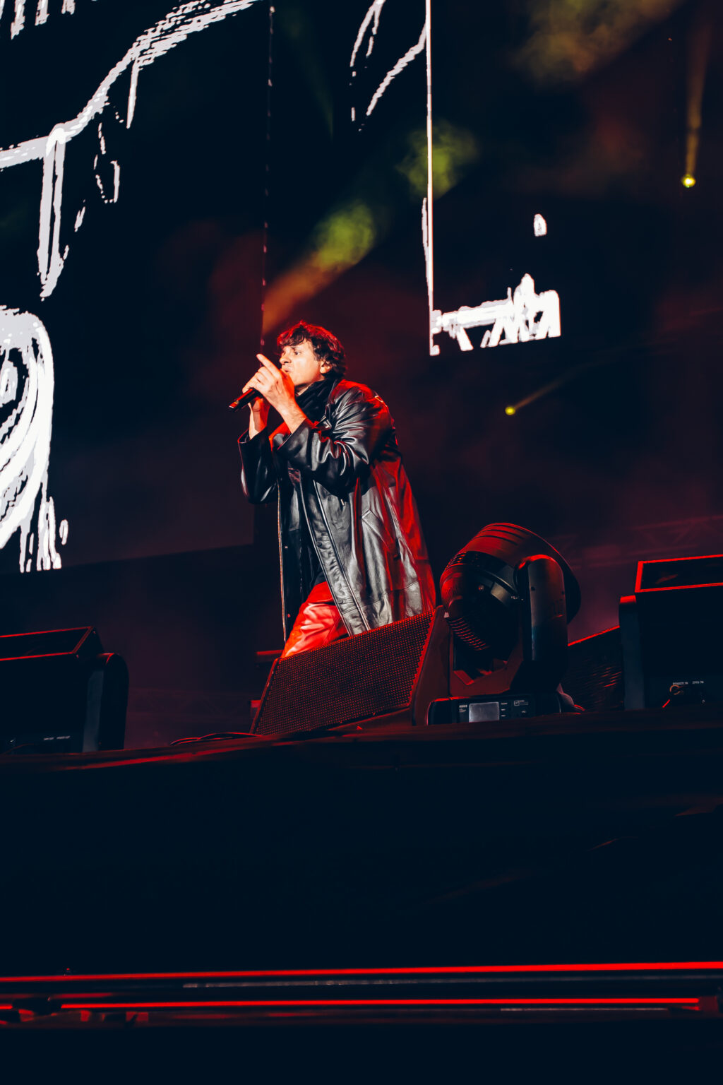 Singer in a red jacket on the darkened stage — Ciro y los Persas at Estadio José Amalfitani, Vélez Sarsfield, Buenos Aires, 9 September 2023. Photographed by Anita Almaraz.