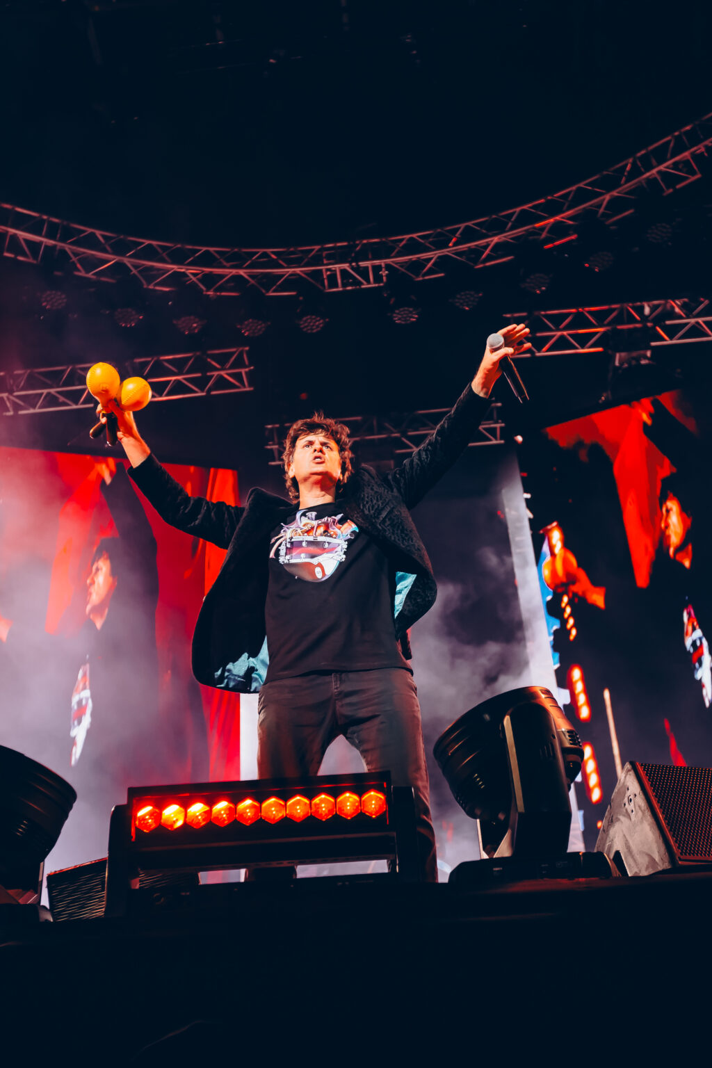 Singer with his arm up, seen from the photo pit — Ciro y los Persas at Estadio José Amalfitani, Vélez Sarsfield, Buenos Aires, 9 September 2023. Photographed by Anita Almaraz.