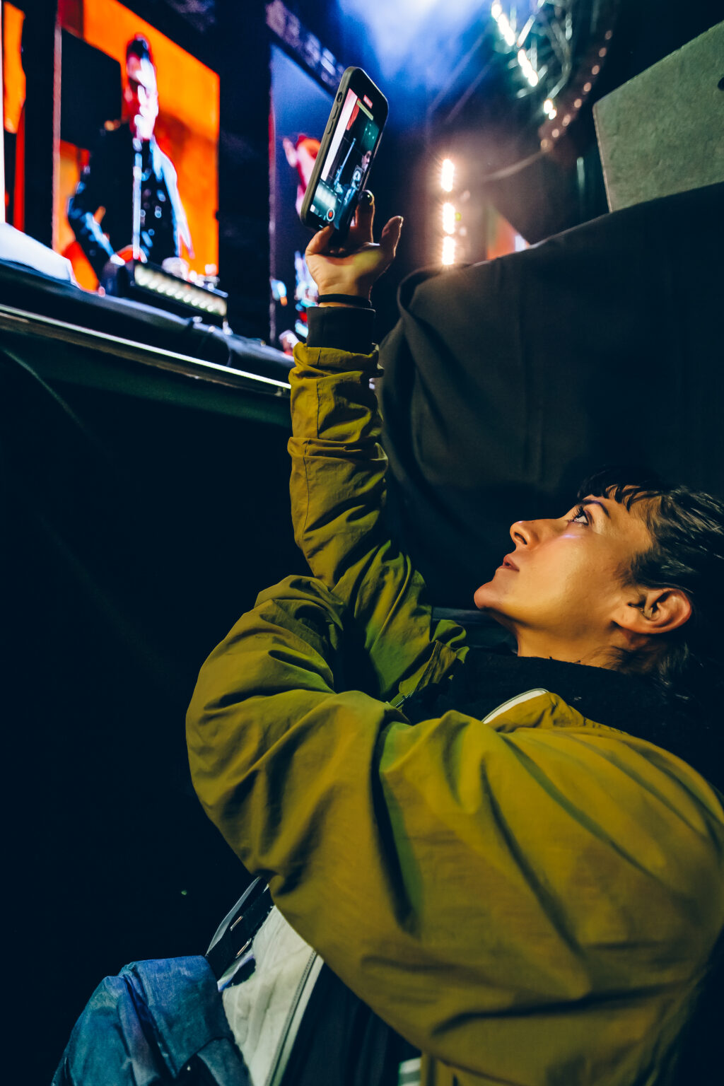 A fan filming the stadium screen with a phone — Ciro y los Persas at Estadio José Amalfitani, Vélez Sarsfield, Buenos Aires, 9 September 2023. Photographed by Anita Almaraz.