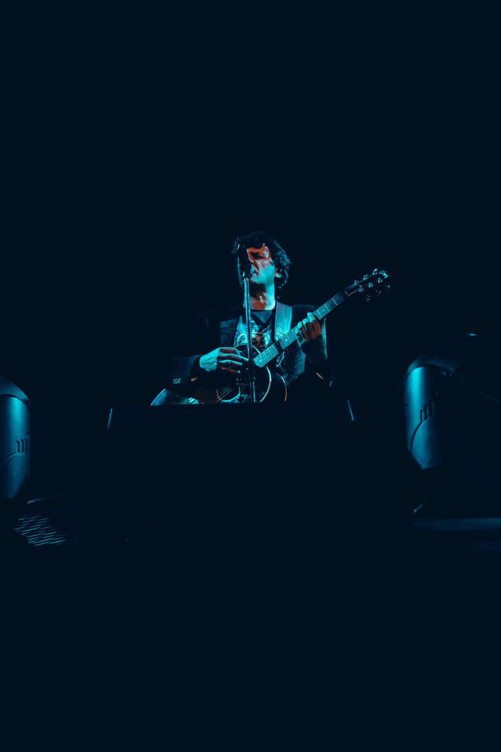 Guitarist alone on the darkened stage — Ciro y los Persas at Estadio José Amalfitani, Vélez Sarsfield, Buenos Aires, 9 September 2023. Photographed by Anita Almaraz.