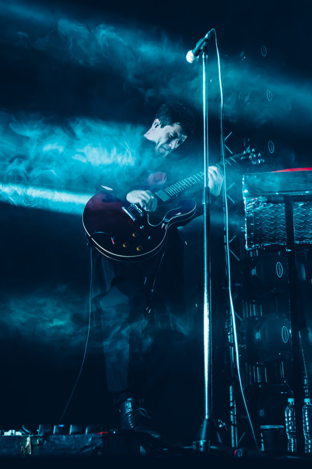 Guitarist with a semi-hollow guitar in the blue haze — Peces Raros at Estadio Obras Sanitarias, Buenos Aires, 7 October 2023. Photographed by Anita Almaraz.