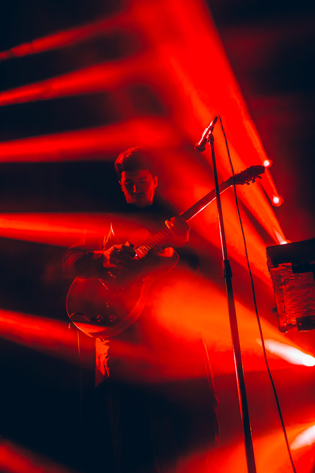 The drum kit under red beams — Peces Raros at Estadio Obras Sanitarias, Buenos Aires, 7 October 2023. Photographed by Anita Almaraz.