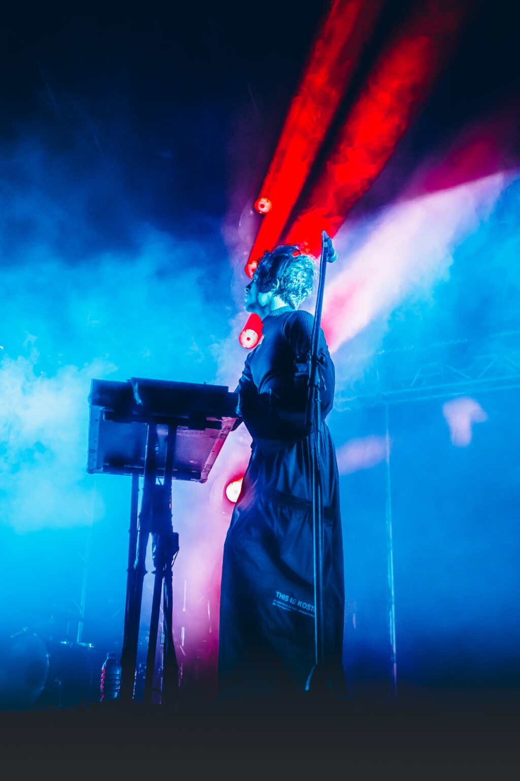 Singer at the keyboards under pink and blue curtains of light — Peces Raros at Estadio Obras Sanitarias, Buenos Aires, 7 October 2023. Photographed by Anita Almaraz.