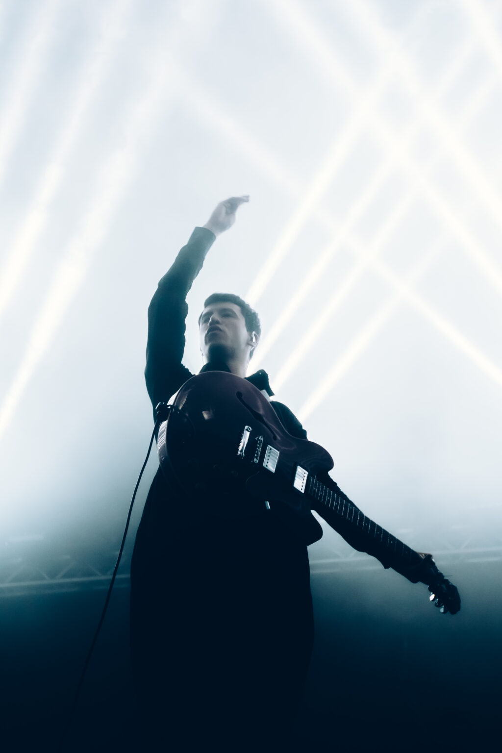 Singer with an arm raised, backlit — Peces Raros at Estadio Obras Sanitarias, Buenos Aires, 7 October 2023. Photographed by Anita Almaraz.