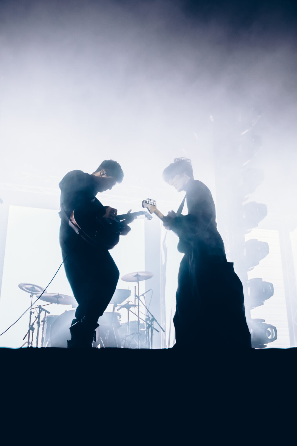 Two members of the band face to face in the smoke — Peces Raros at Estadio Obras Sanitarias, Buenos Aires, 7 October 2023. Photographed by Anita Almaraz.