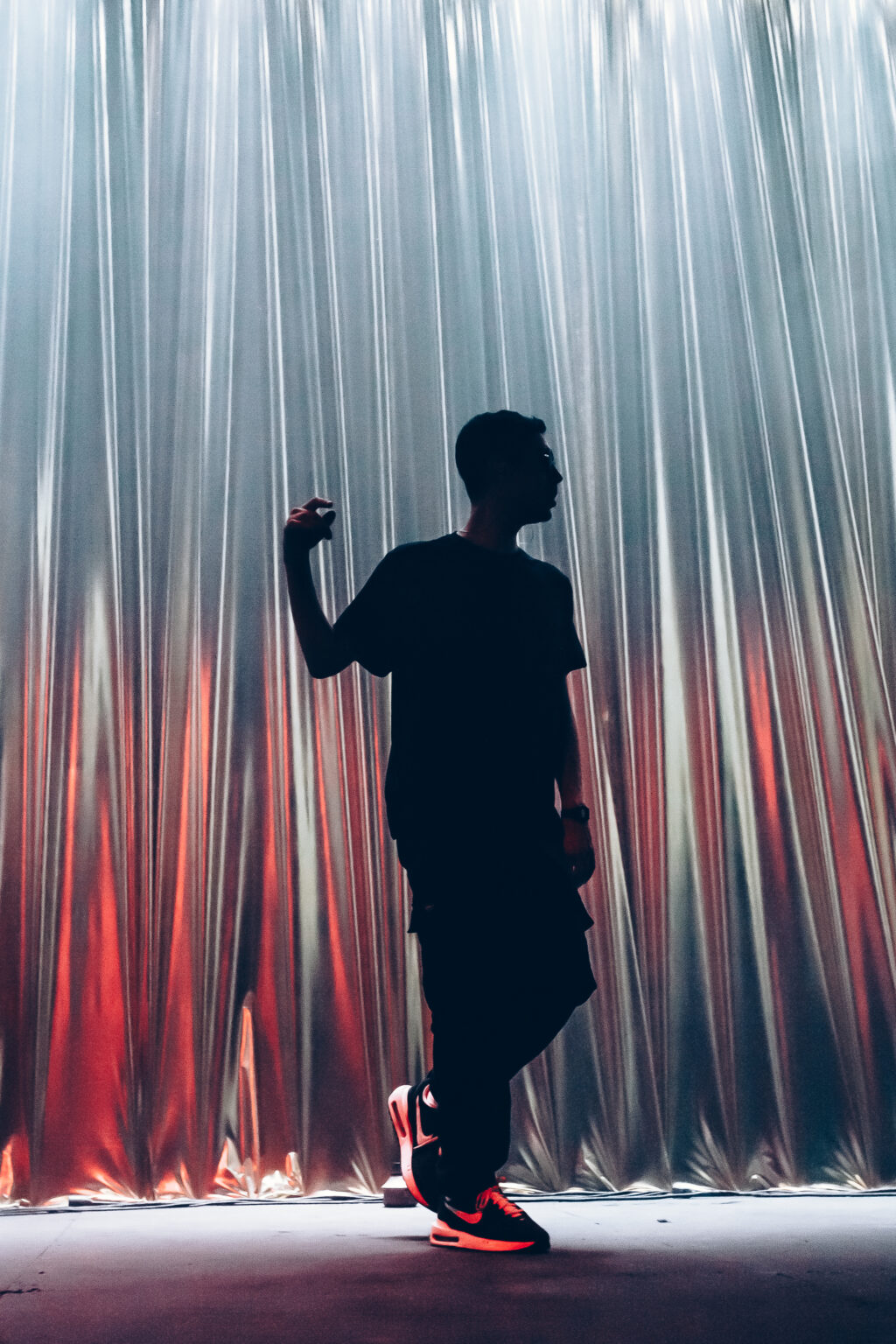 Singer in silhouette mid-step under the fringe curtain — El Kuelgue at C Complejo Art Media, Buenos Aires, 23 November 2023. Photographed by Anita Almaraz.