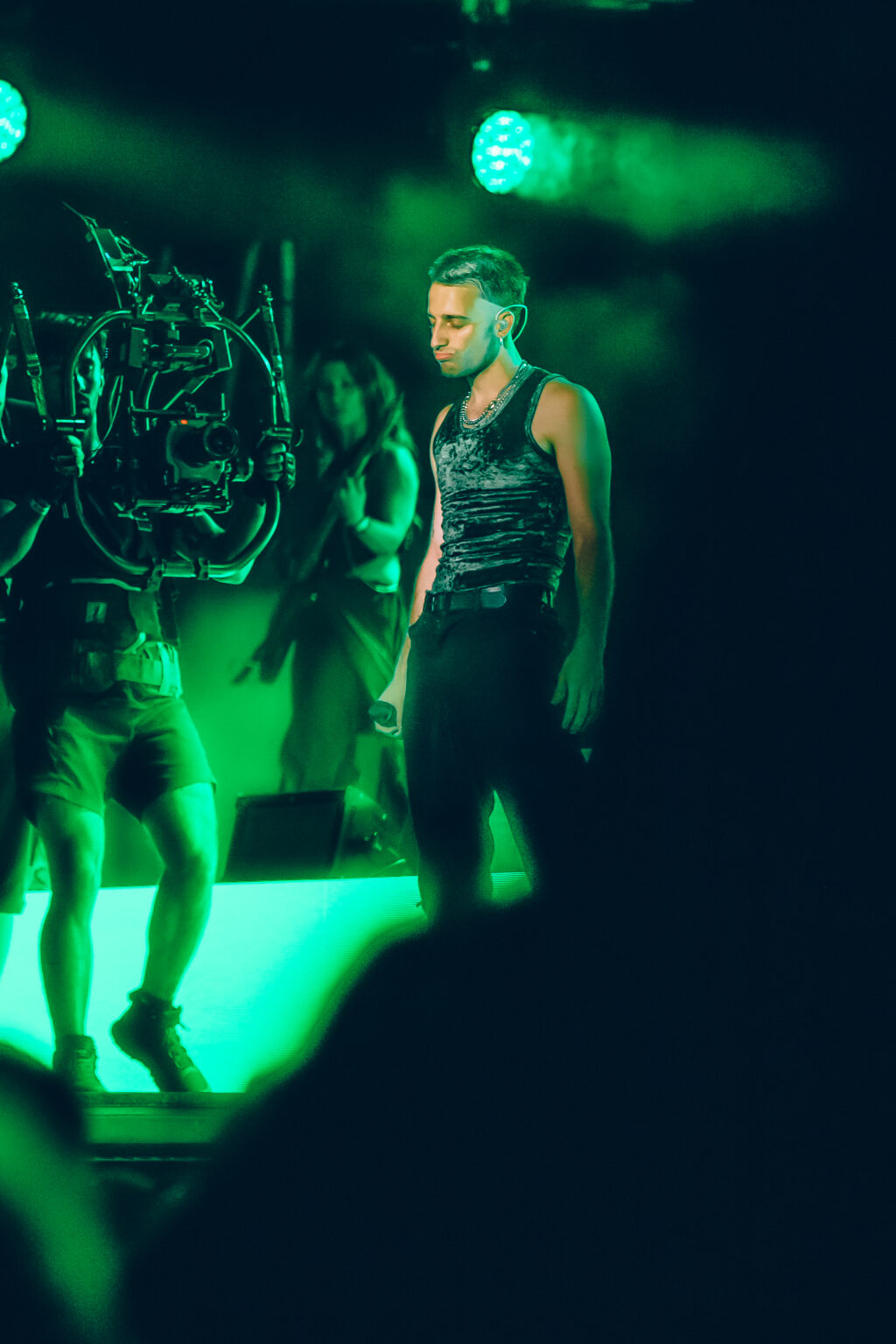 Wos on stage among the green set pieces — Wos live in Buenos Aires, photographed by Anita Almaraz.