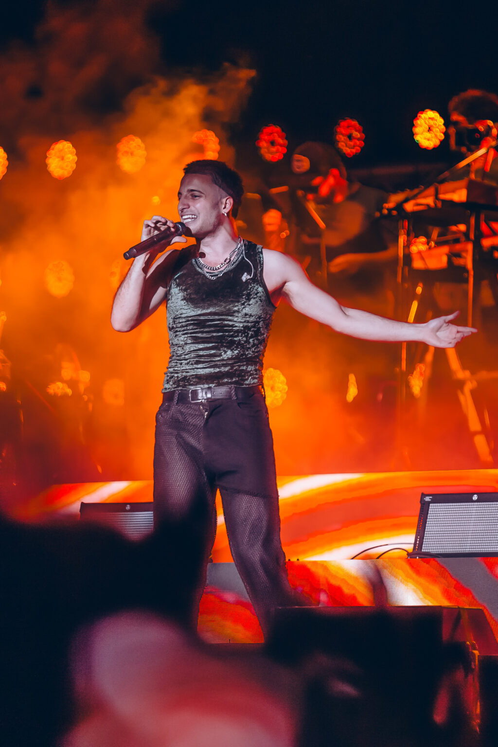 Wos and the band under warm orange light — Wos live in Buenos Aires, photographed by Anita Almaraz.