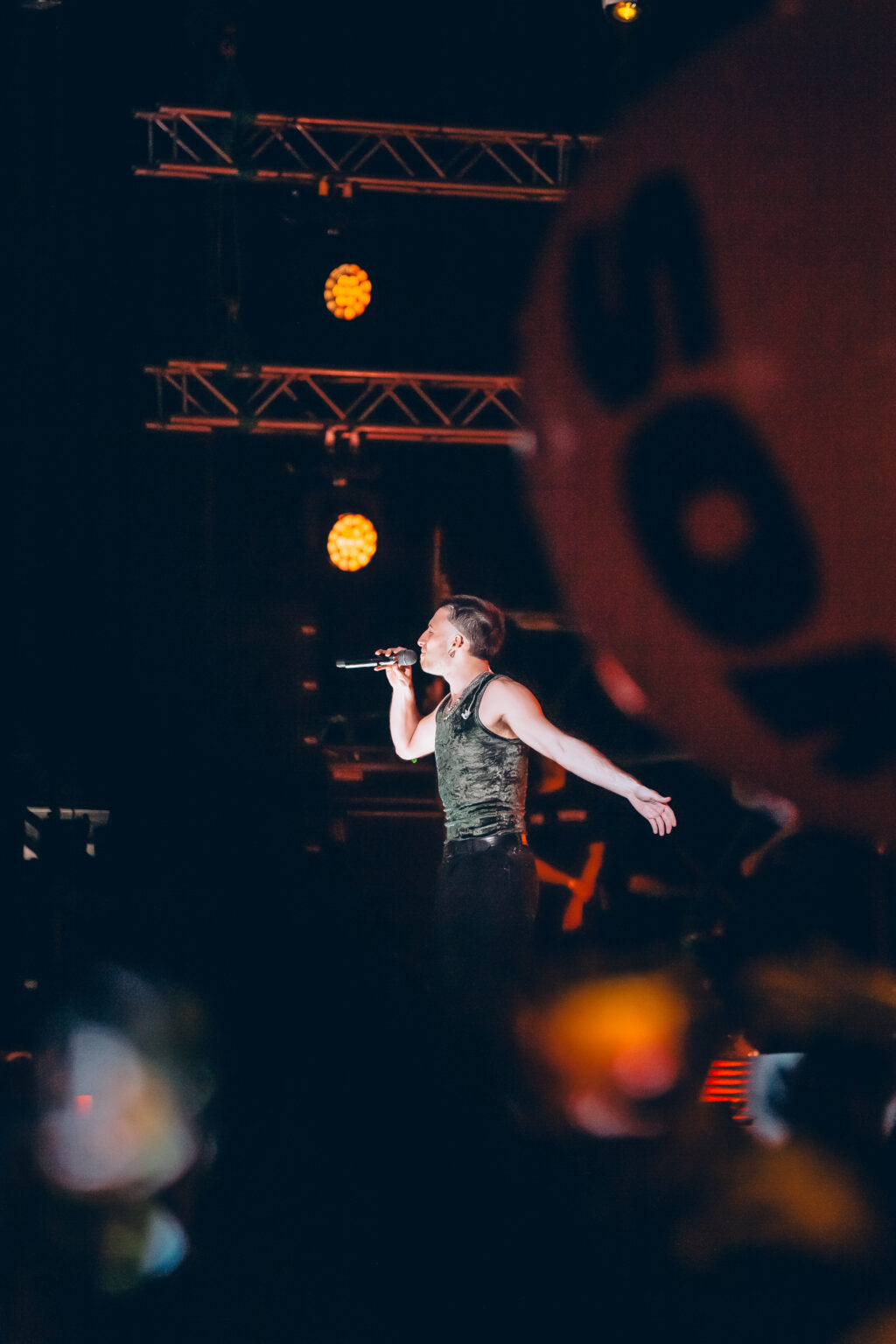 Wos with his arm out in front of the WOS letters — Wos live in Buenos Aires, photographed by Anita Almaraz.