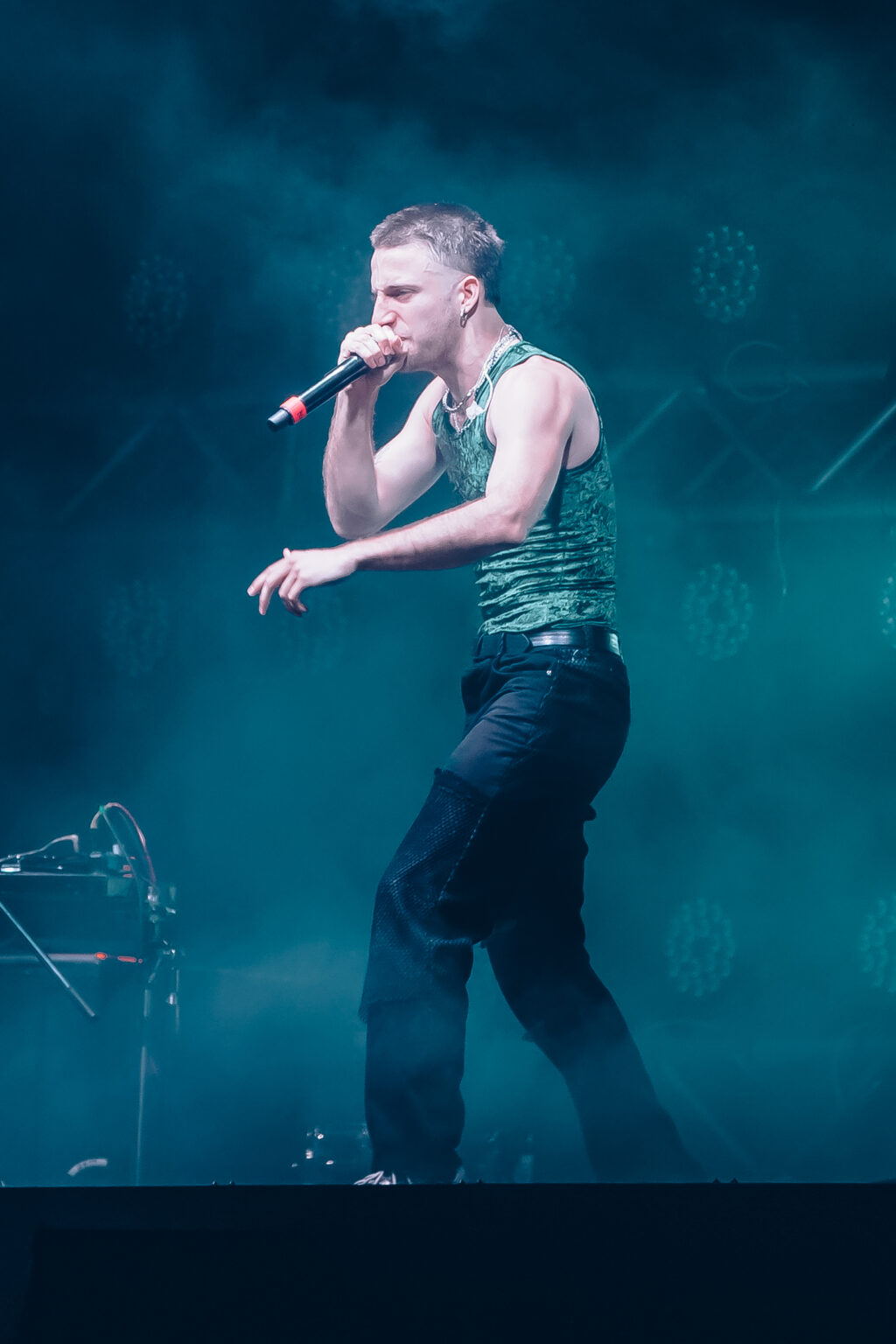 Wos singing, lit from the side — Wos live in Buenos Aires, photographed by Anita Almaraz.