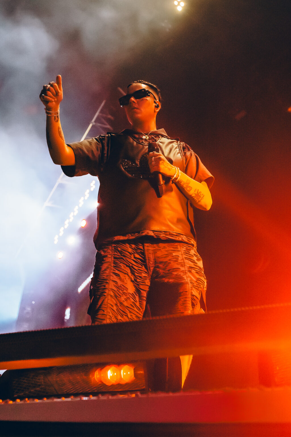 Duki with an arm raised above the barricade lights — Duki at Estadio River Plate, Buenos Aires, 2 December 2023. Photographed by Anita Almaraz.