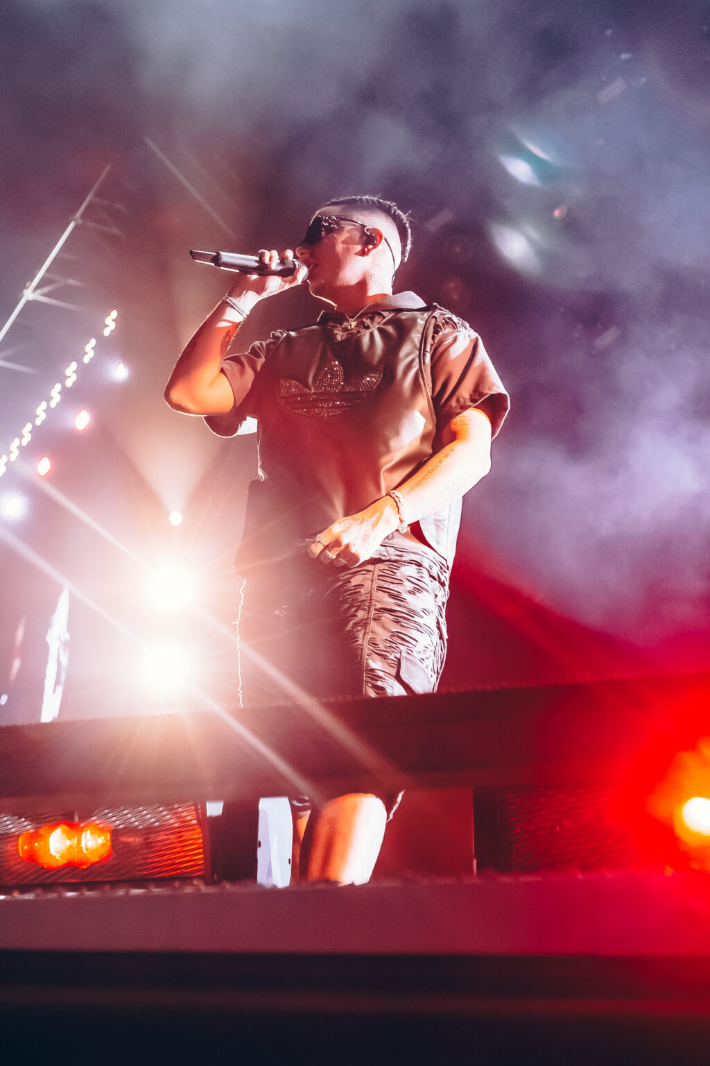 Duki at the microphone with the stage lights behind him — Duki at Estadio River Plate, Buenos Aires, 2 December 2023. Photographed by Anita Almaraz.