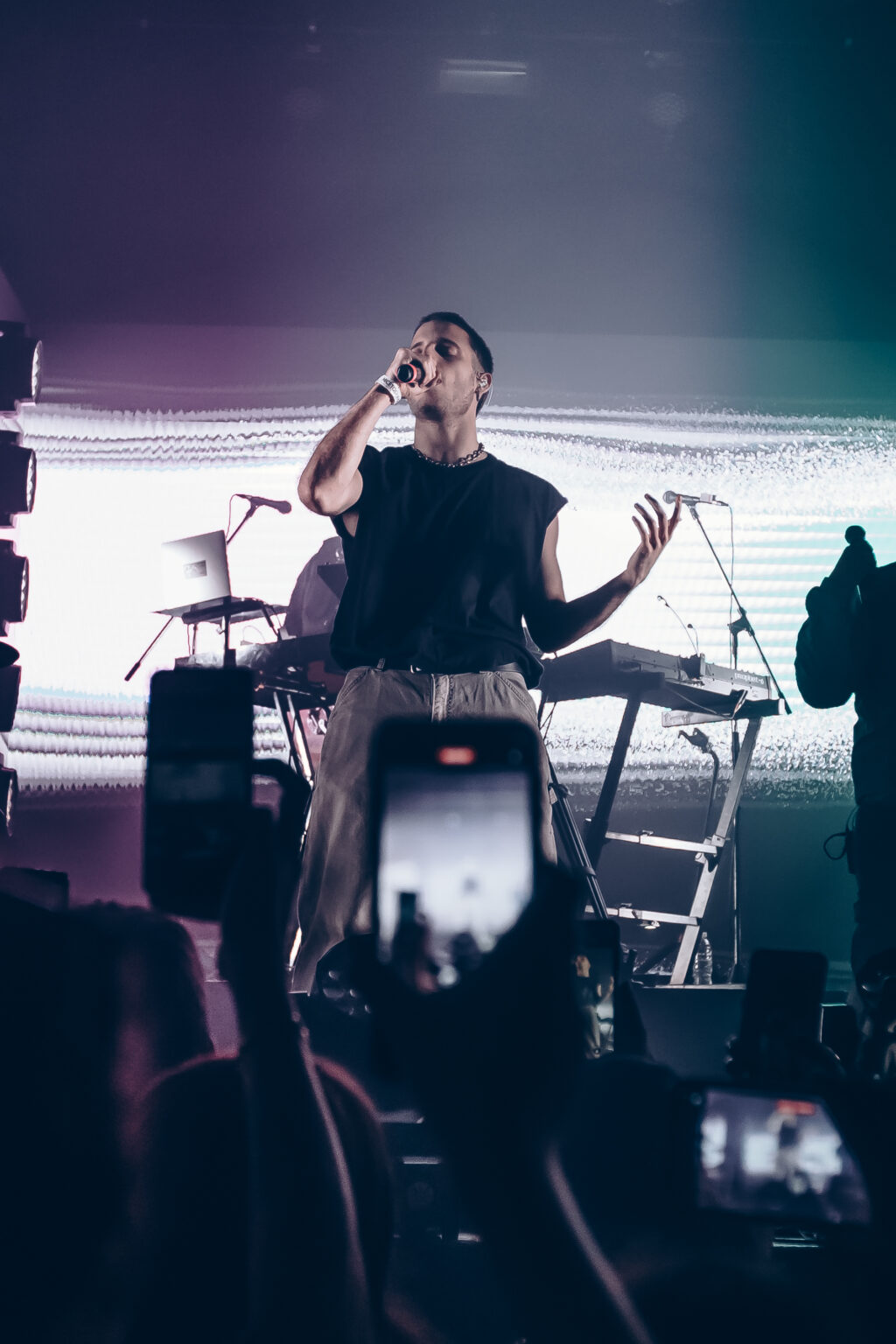Singer at the microphone with phones raised in the crowd — Evlay at Niceto Club, Buenos Aires, 19 December 2023. Photographed by Anita Almaraz.