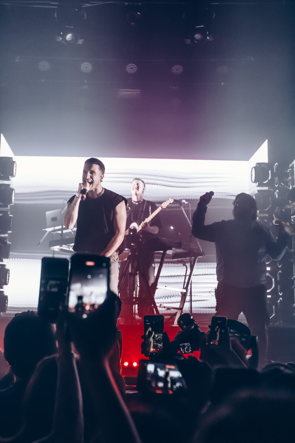 The band with arms raised under red light — Evlay at Niceto Club, Buenos Aires, 19 December 2023. Photographed by Anita Almaraz.