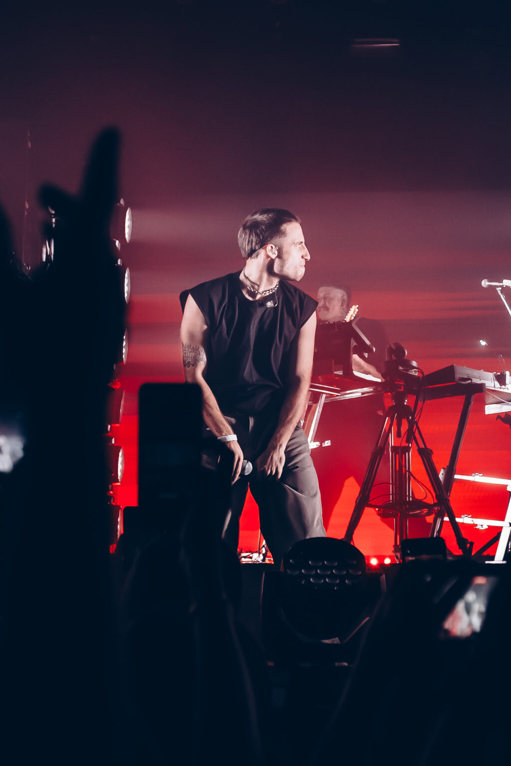 A hand raised in the crowd in front of the red stage — Evlay at Niceto Club, Buenos Aires, 19 December 2023. Photographed by Anita Almaraz.