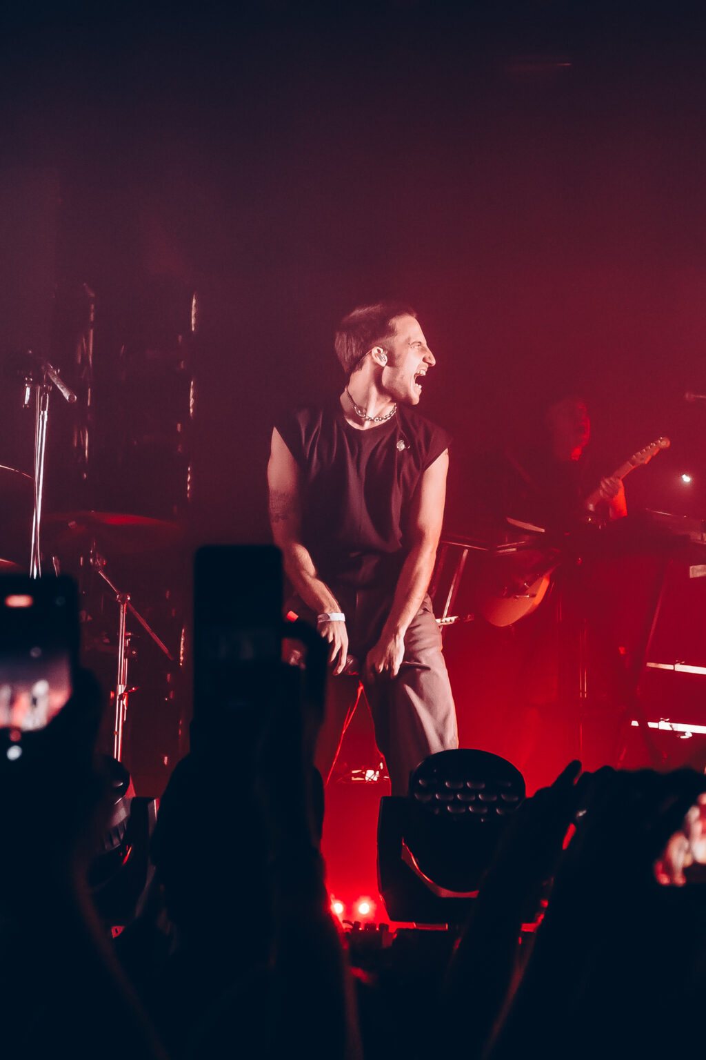 Singer leaning toward the crowd under red light — Evlay at Niceto Club, Buenos Aires, 19 December 2023. Photographed by Anita Almaraz.