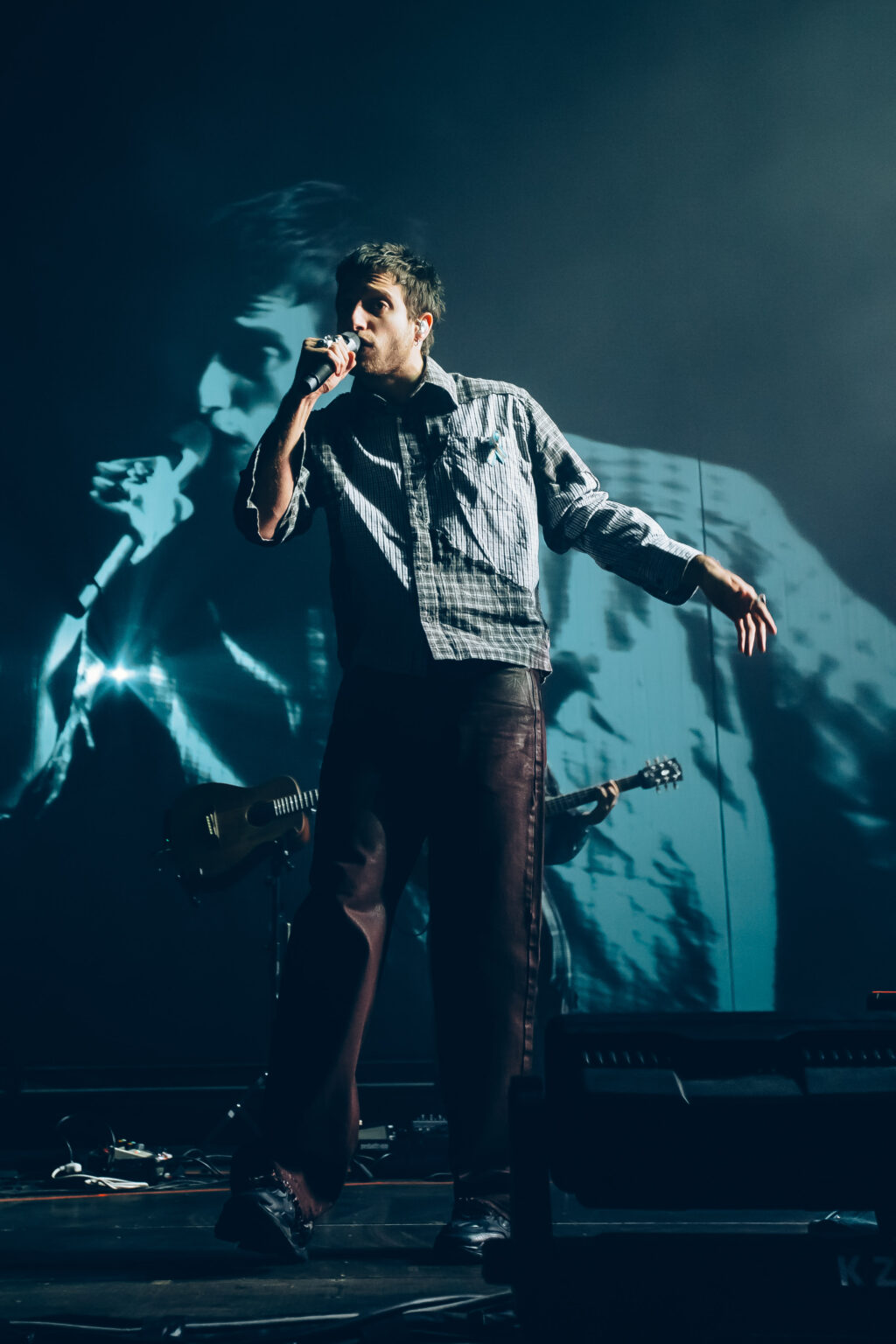 Wos singing in front of the video projection — Wos live in Buenos Aires, photographed by Anita Almaraz.