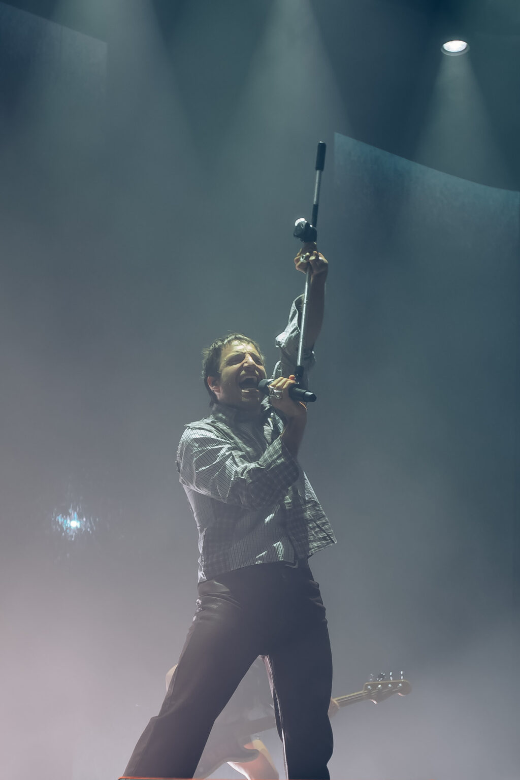 Wos in silhouette against a white stage beam — Wos live in Buenos Aires, photographed by Anita Almaraz.
