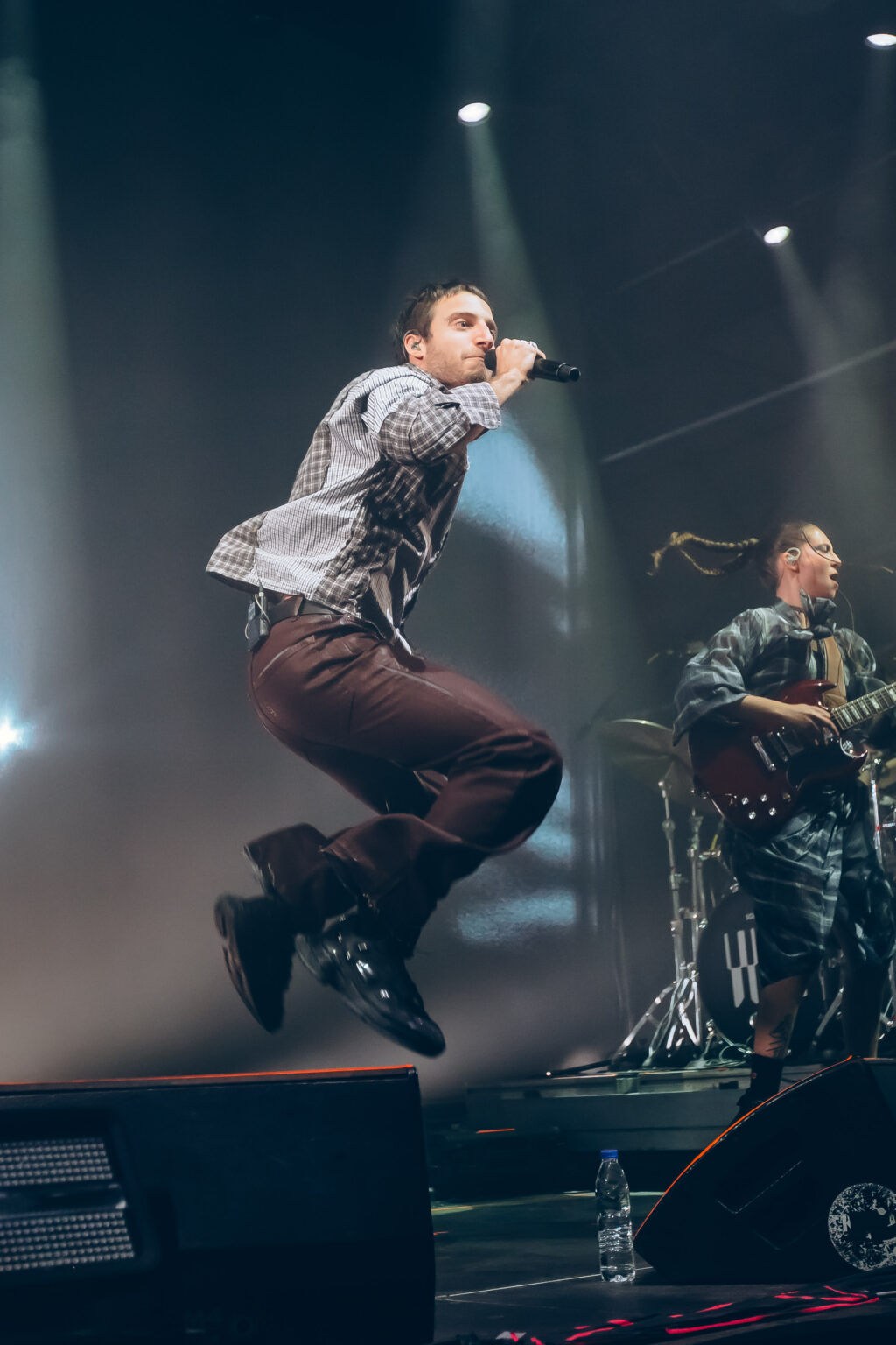 Wos mid-jump with the band behind him — Wos live in Buenos Aires, photographed by Anita Almaraz.