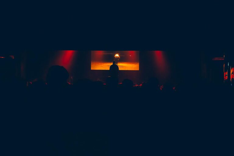 The darkened stage under red light — Zeballos presenting Asimetría at Vorterix, Buenos Aires, 2026. Photographed by Anita Almaraz.