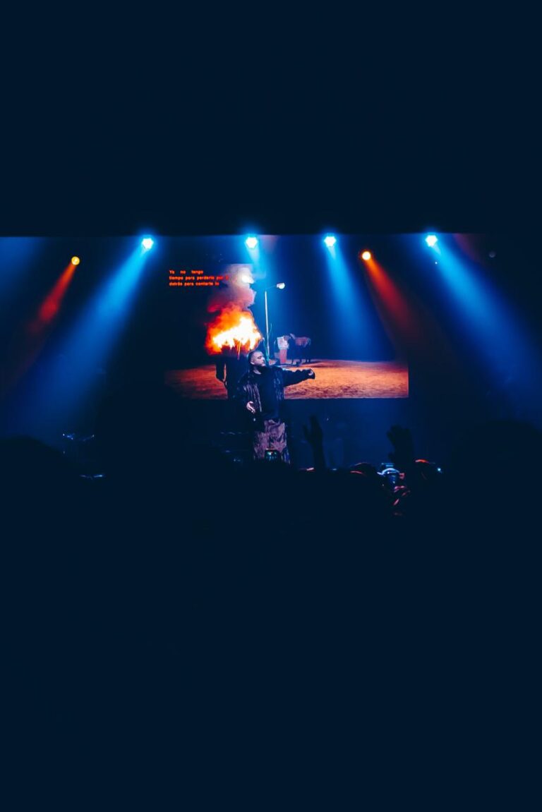 The stage lit in red and blue, seen from the floor — Zeballos presenting Asimetría at Vorterix, Buenos Aires, 2026. Photographed by Anita Almaraz.
