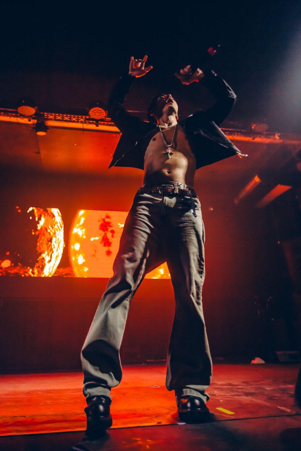Performer with both arms up against the orange backdrop — Way Better at Club Cultural Matienzo, Buenos Aires, 2026. Photographed by Anita Almaraz.