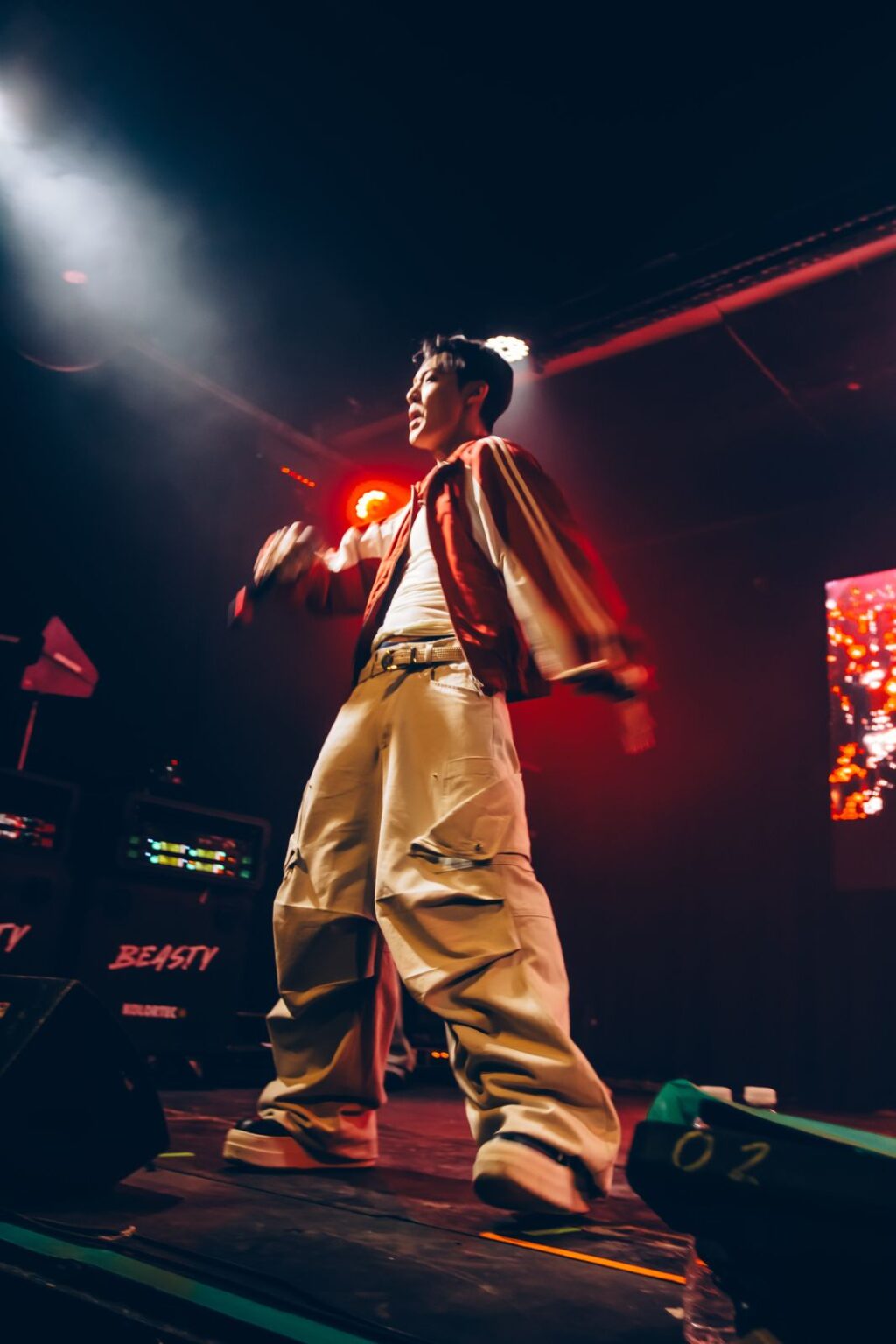 Performer at the edge of the stage with a red light flare — Way Better at Club Cultural Matienzo, Buenos Aires, 2026. Photographed by Anita Almaraz.