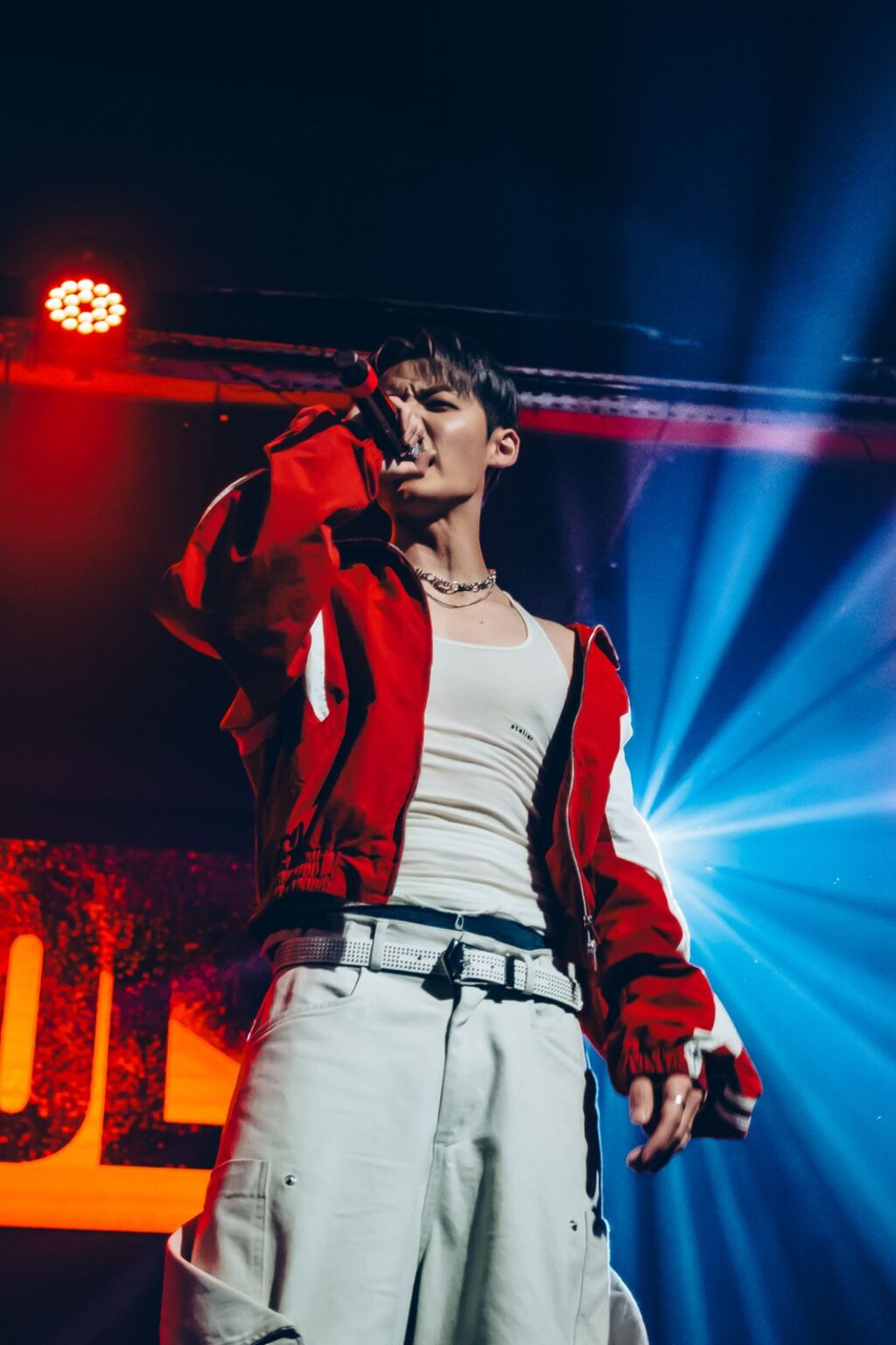Performer in a red jacket against blue beams — Way Better at Club Cultural Matienzo, Buenos Aires, 2026. Photographed by Anita Almaraz.