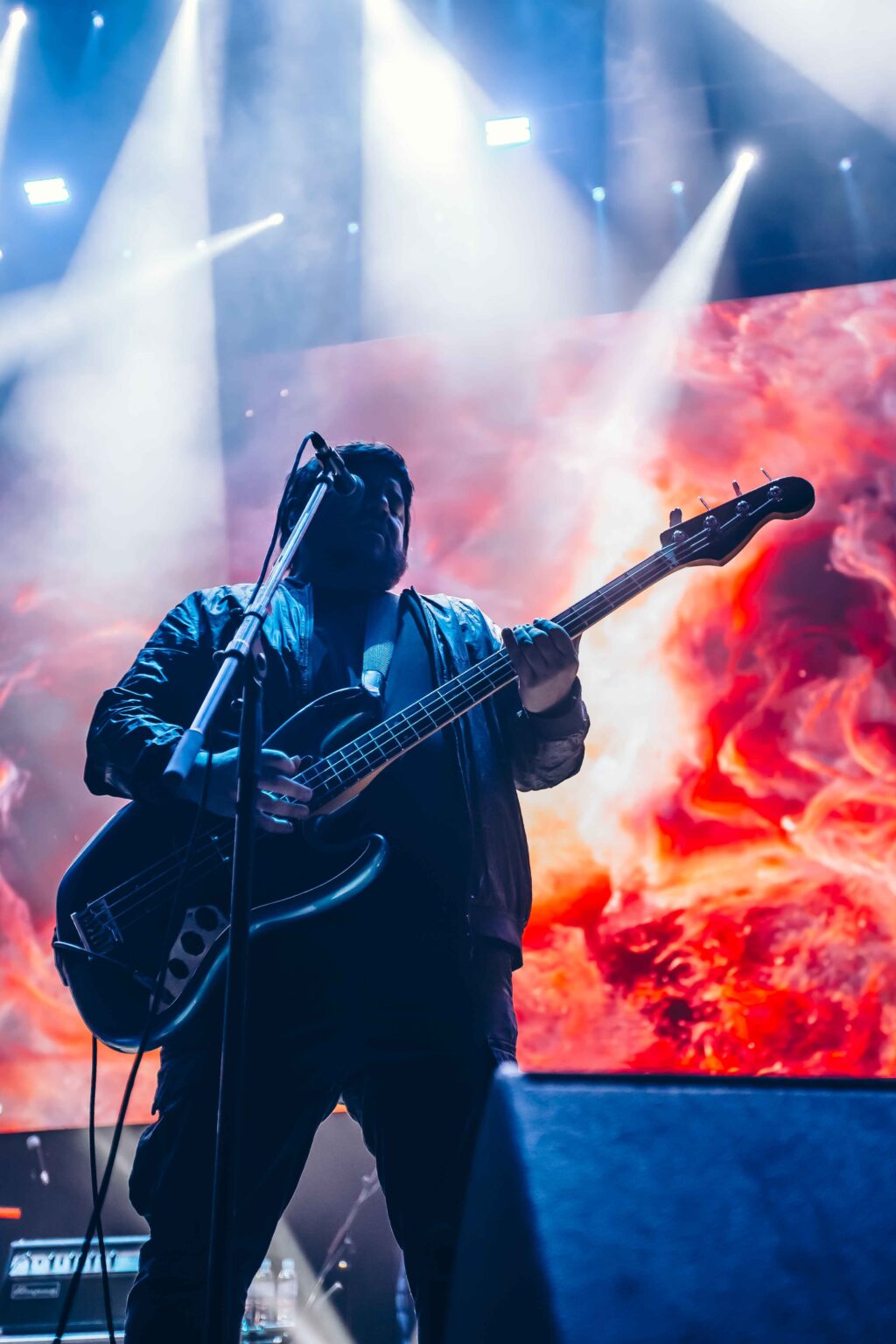 Guitarist against the red and orange screen — El Mató a un Policía Motorizado at Movistar Arena, Buenos Aires, 16 June 2024. Photographed by Anita Almaraz.