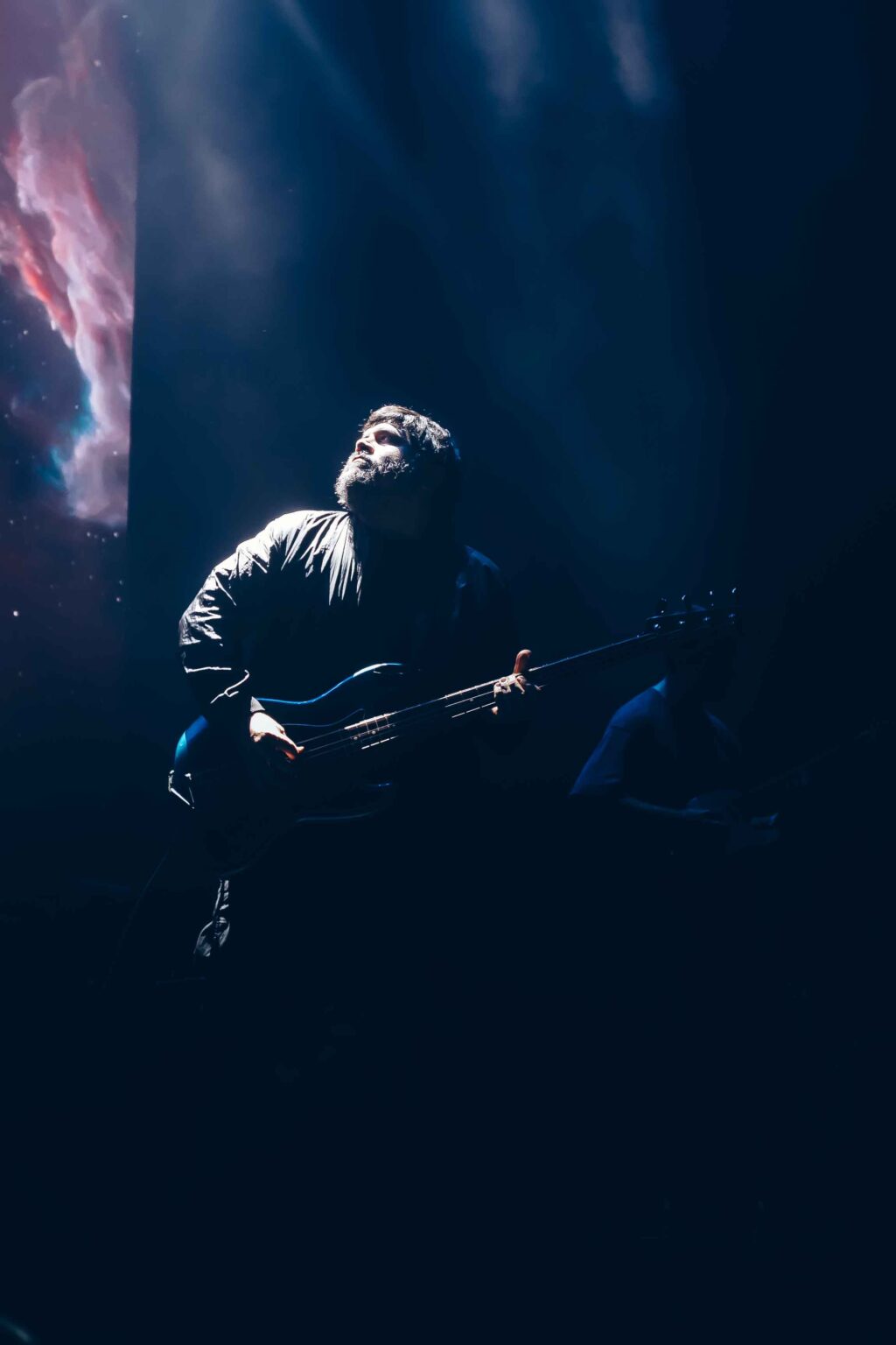 Guitarist alone in the dark at the side of the stage — El Mató a un Policía Motorizado at Movistar Arena, Buenos Aires, 16 June 2024. Photographed by Anita Almaraz.