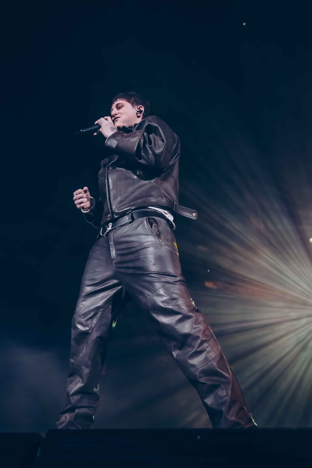 Dillom with his legs apart under a starburst of light — Dillom at Estadio Luna Park, Buenos Aires, 19 June 2024. Photographed by Anita Almaraz.