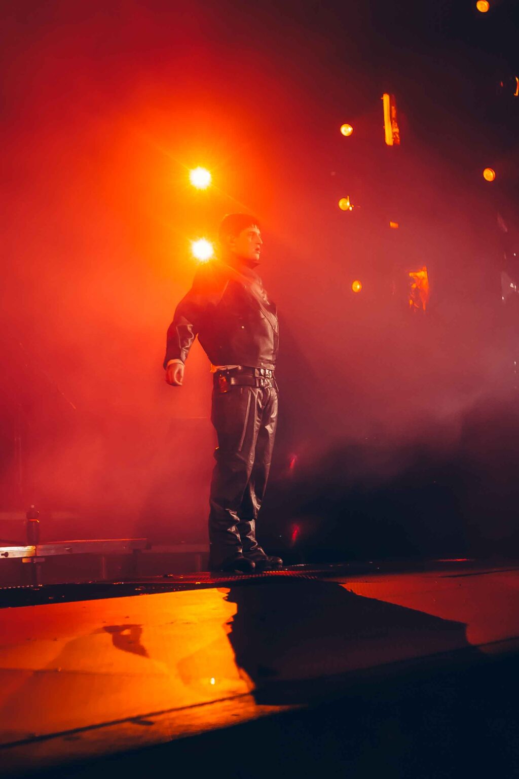 Dillom standing against the red and orange lights — Dillom at Estadio Luna Park, Buenos Aires, 19 June 2024. Photographed by Anita Almaraz.