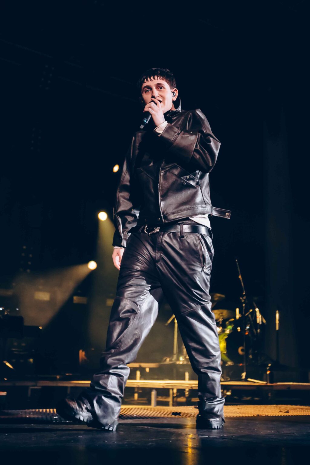 Dillom at the microphone with the stage lights behind — Dillom at Estadio Luna Park, Buenos Aires, 19 June 2024. Photographed by Anita Almaraz.
