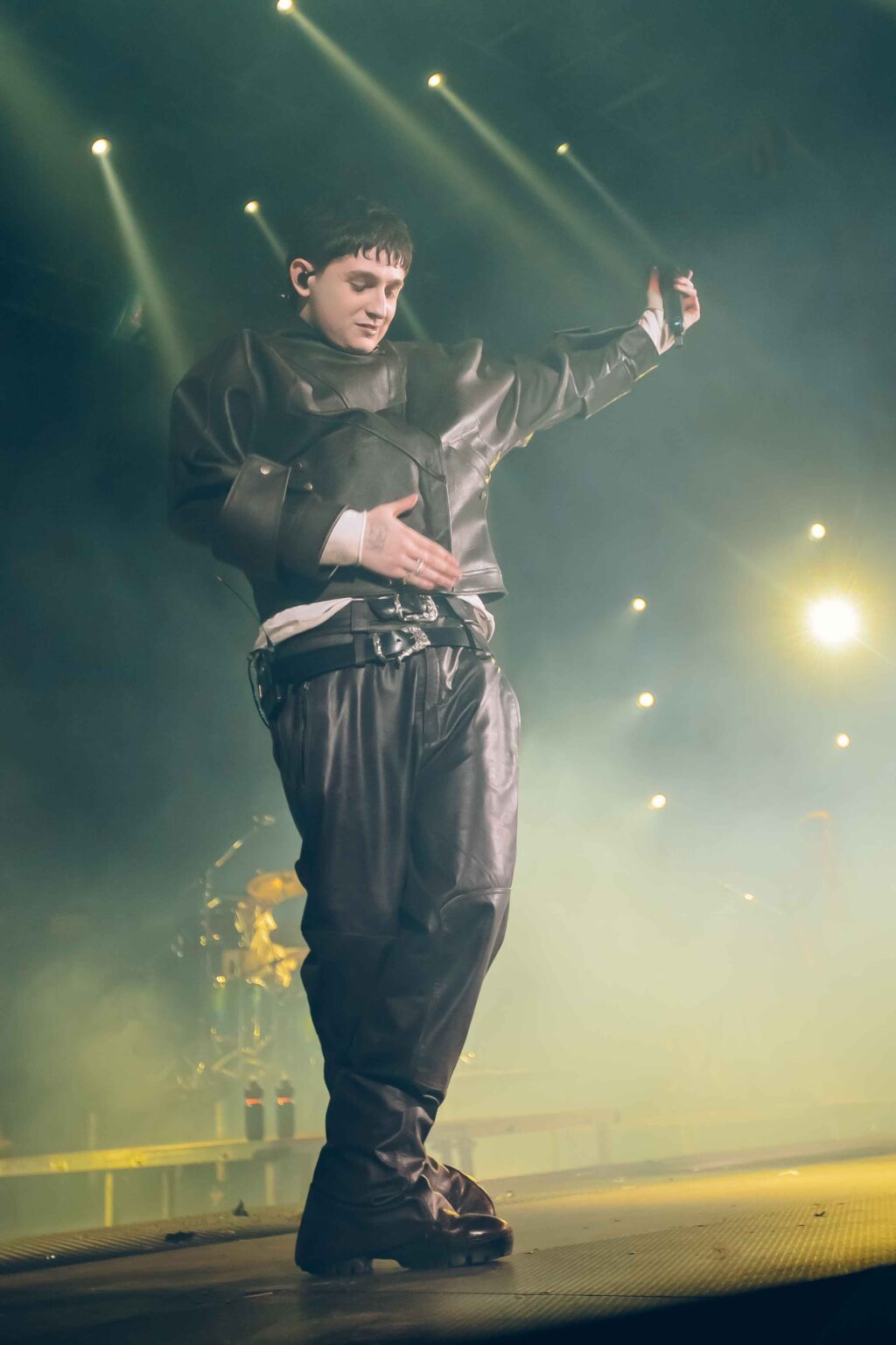 Dillom under yellow beams with his arms open — Dillom at Estadio Luna Park, Buenos Aires, 19 June 2024. Photographed by Anita Almaraz.